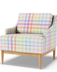 Armchair upholstered in large scale pastel rainbow gingham fabric, soft pink, blue, lilac, mint and lemon checks on white with natural wooden legs.