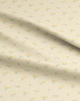 Pale neutral fabric with hand-drawn yellow daffodils and crocus ideal for spring sewing, nursery decor, and seasonal home accents.