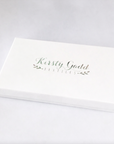 White presentation gift box with Kirsty Gadd Textiles branding in soft green lettering, elegant packaging for floral tea towel gift
