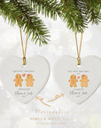 Two heart-shaped ceramic ornaments showing gingerbread couple designs, one reading ‘Our First Christmas Engaged’ and the other ‘Our First Christmas as Fiancés,’ displayed together with a gold hanging cord and festive bokeh background