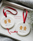 Personalised gingerbread couple Christmas ornament with “Our First Christmas as Fiancés” and the names Alex and James, displayed in a basket of glittery red and gold baubles with fairy lights
