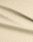 Cream fabric with small scattered yellow and pastel floral ditsy print, inspired by spring blooms in a cottage garden
