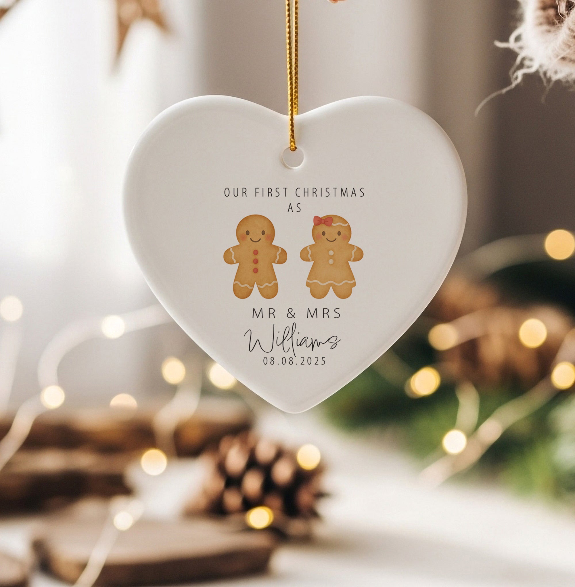 Personalised Mr & Mrs gingerbread couple ornament with wedding date and surname printed on a white heart-shaped ceramic bauble, styled in a cosy festive setting.