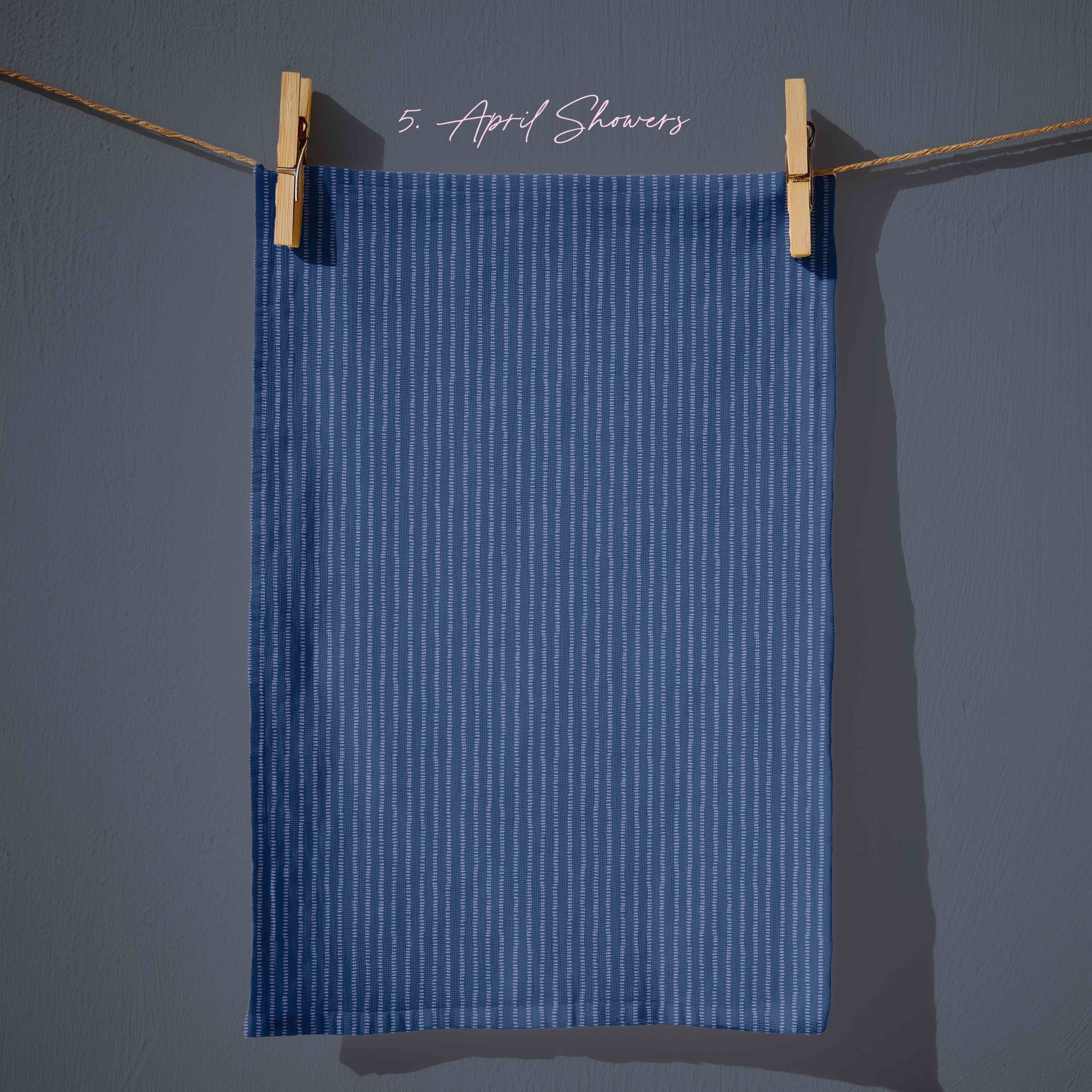 Deep navy blue striped tea towel with fine vertical dash lines, subtle rain-inspired pattern for farmhouse spring kitchens.
