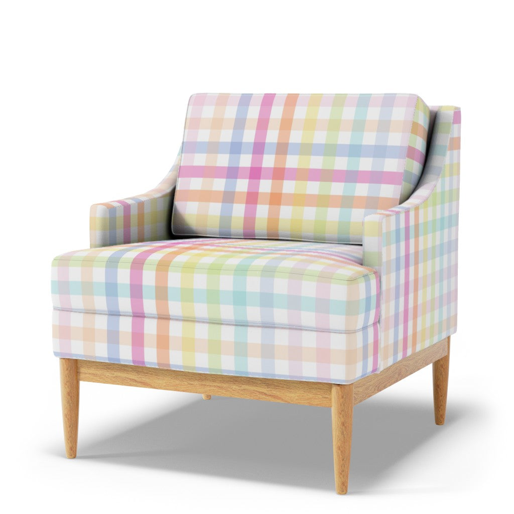 Armchair upholstered in large scale pastel rainbow gingham fabric, soft pink, blue, lilac, mint and lemon checks on white with natural wooden legs.