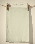 Light pastel sage green floral tea towel with tiny yellow daffodil ditsy repeat pattern, soft pastel spring kitchen textile in cottagecore farmhouse style