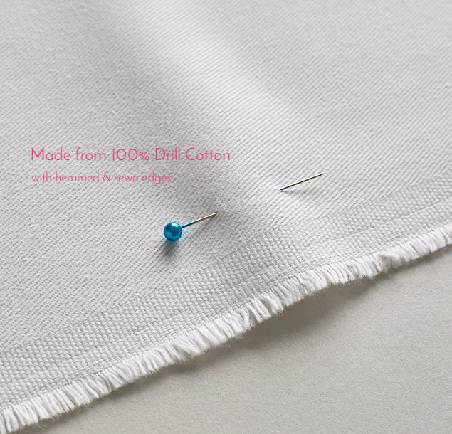 Close up of 100% drill cotton tea towel fabric showing woven texture, edges will be hemmed and sewn 