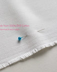 Close up of 100% drill cotton tea towel fabric showing woven texture, edges will be hemmed and sewn 