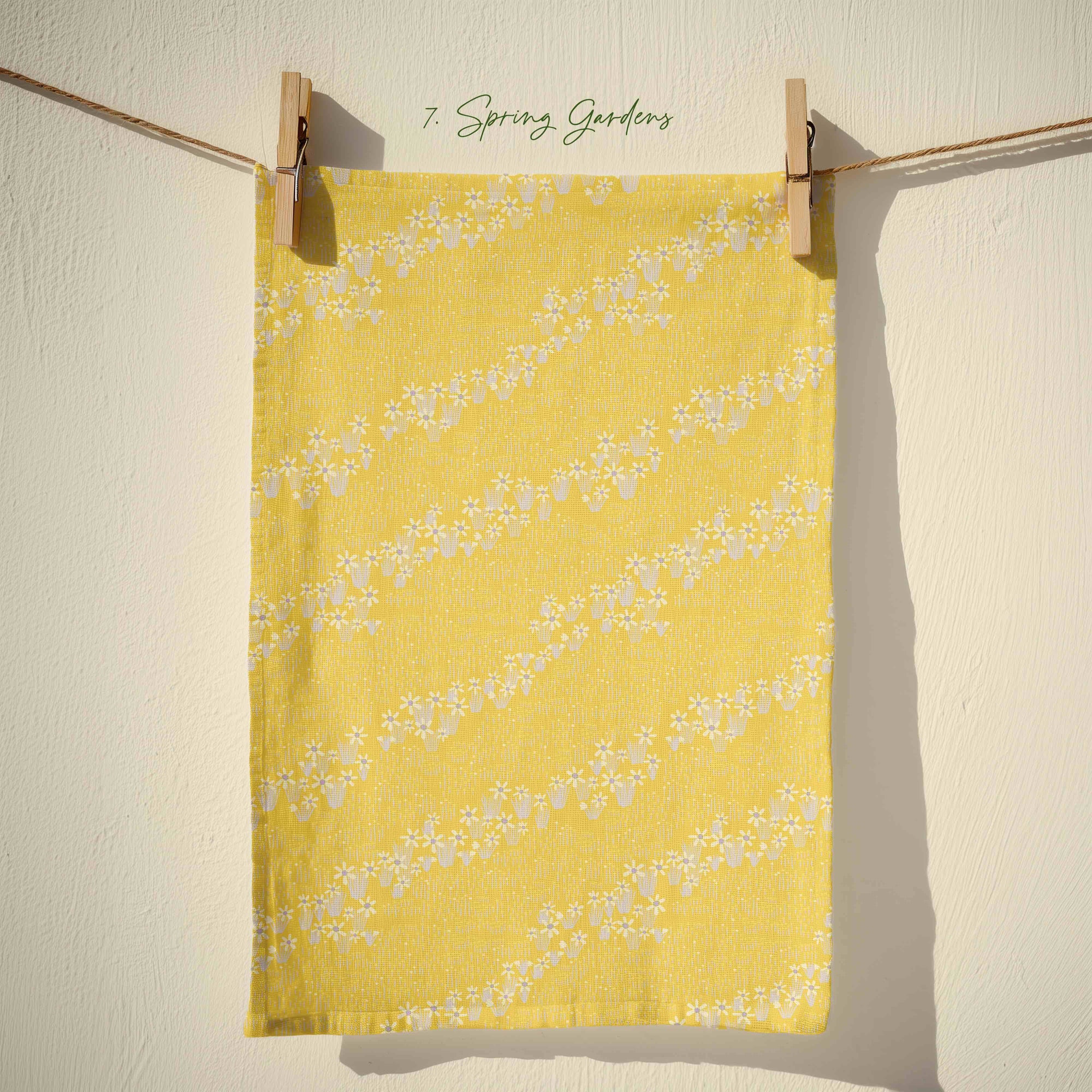 Bright yellow floral tea towel with flowing white blossom garlands in a bold spring country garden print, cheerful cottagecore kitchen decor