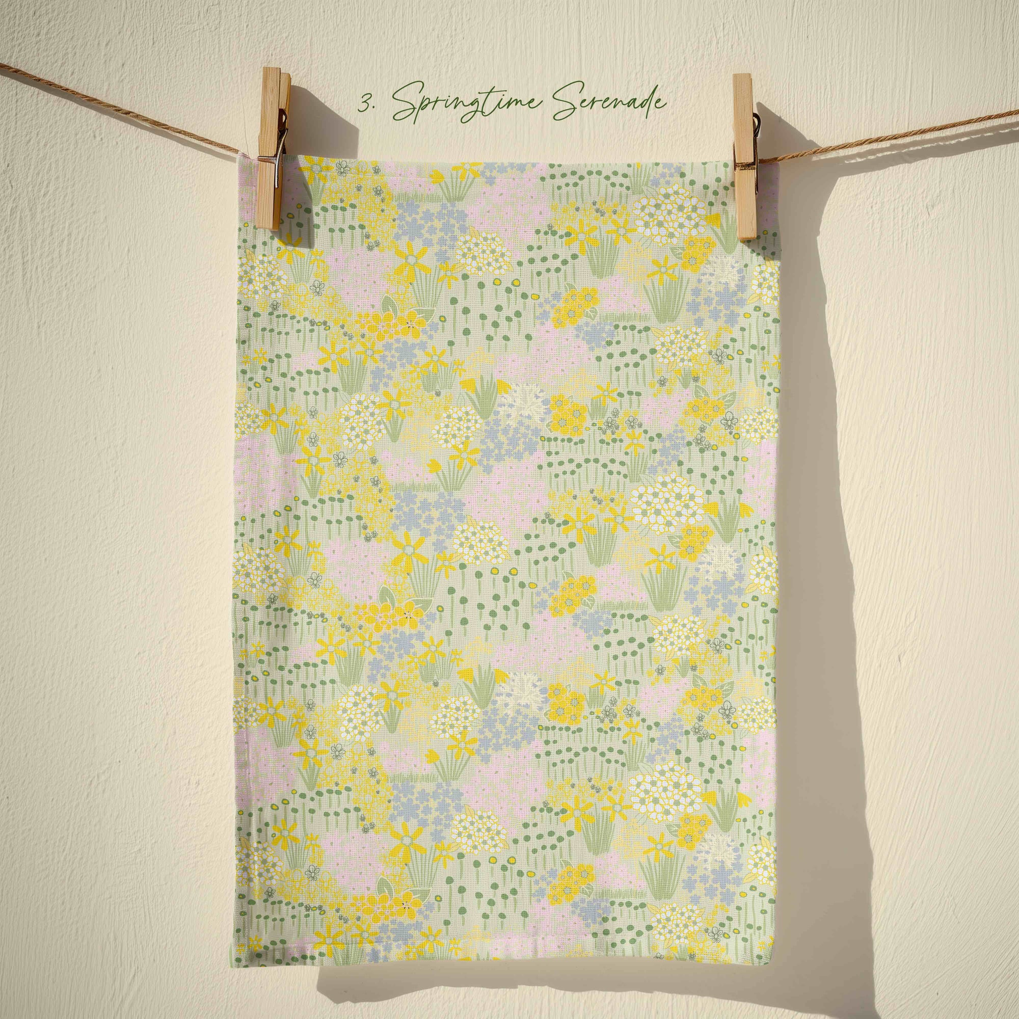 Pastel floral tea towel featuring yellow daffodils, blush pink blossom and sage green foliage in an all over country garden spring print