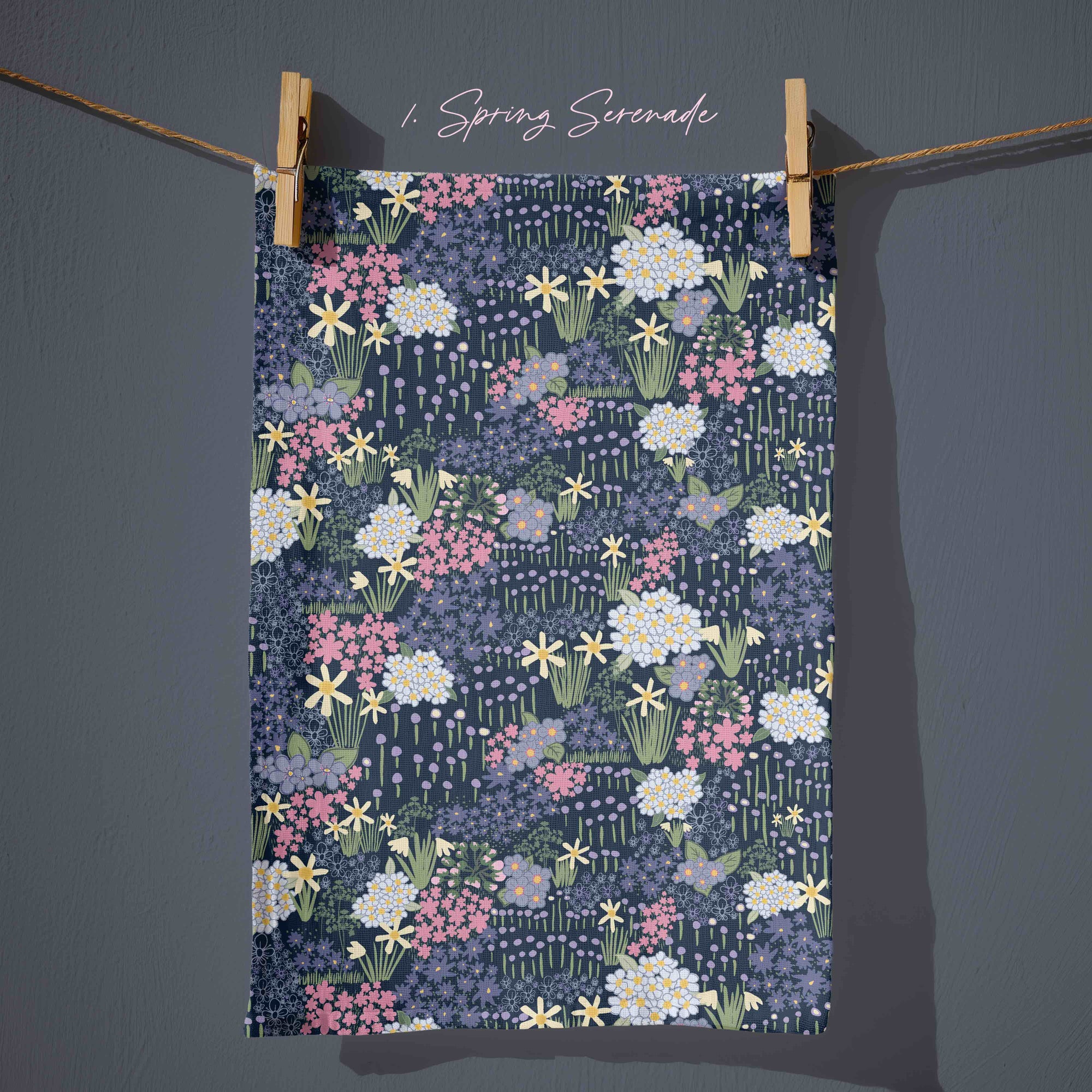 Navy blue floral tea towel with daffodils, blossom and wild garden flowers in soft pink, butter yellow and sage green, inspired by English cottage garden borders at dusk.