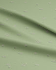 Sage green fabric with soft pink floral buds, inspired by early spring flowers in a Somerset garden. On cotton fabric.